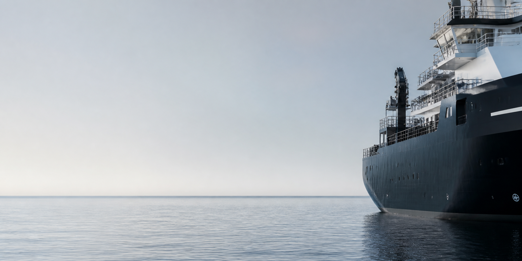 The starboard side of a dark marine vessel at a calm, open horizon